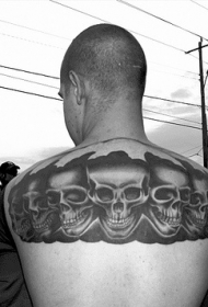 男性背部黑色的一排骷髅纹身图案