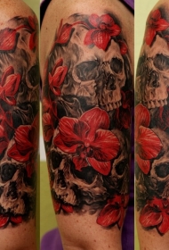 大臂美丽的红色兰花和黑色骷髅纹身图案