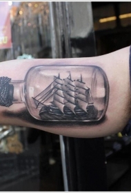 手臂一个密封的瓶子和帆船纹身图案
