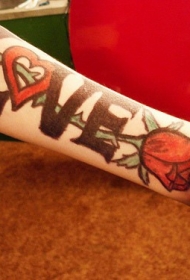 手臂黑色的英文字母与红色玫瑰纹身图案