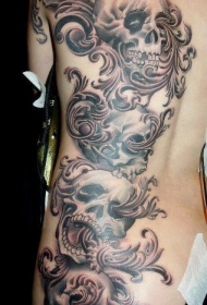 背部黑灰色的骷髅和花卉纹身图案