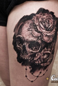 大腿写实风格的黑白骷髅和玫瑰花纹身图案