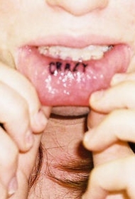 嘴唇内疯狂黑色的字母纹身图案