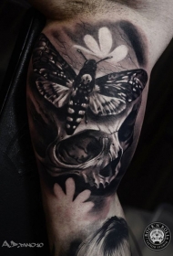 大臂内侧写实的黑白骷髅和蝴蝶纹身图案