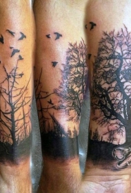 小臂黑色的黑暗森林与小鸟纹身图案