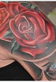大臂简单的彩色玫瑰与神秘的脸纹身图案