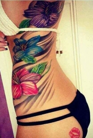女性侧肋三朵彩色的花卉纹身图案
