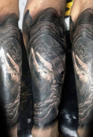 手臂黑灰逼真的大犀牛头部纹身图案