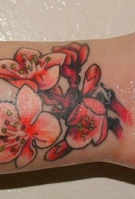 女性手腕内侧的红色桃花纹身图案