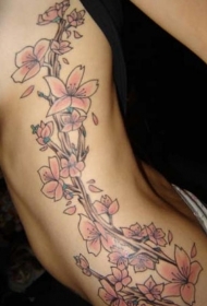 女性腰侧彩色桃花藤蔓纹身图案