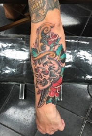 男性手臂传统彩色纹身玫瑰花和骷髅头匕首纹身图片