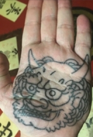 手掌上的带角的唐狮怪兽纹身