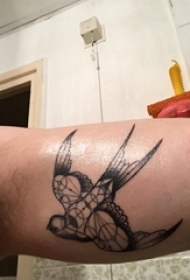 手大臂上的几何风格黑色燕子纹身