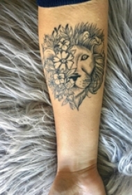 男生手臂上黑灰点刺简单线条植物花朵和狮子拼接纹身图片