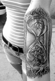 女生手臂上黑色素描创意树枝沙漏纹身图片