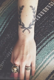 女生手臂上黑色点刺植物素材叶子纹身图片