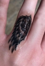 简约手指纹身 女生手指上黑色的翅膀纹身图片