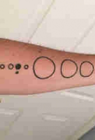 几何元素纹身 男生手臂上黑色的圆形纹身图片