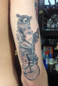熊纹身 男生手臂上骑自行车的狗熊纹身图片