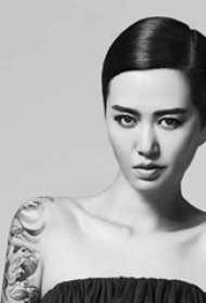 中国纹身明星 谭维维手臂上黑灰色的浪花纹身图片