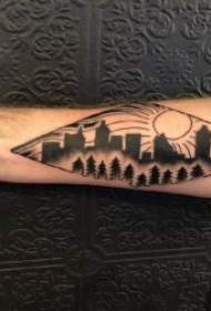 男生小手臂上黑灰纹身松树图案和建筑物图