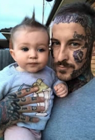 抱着的孩子纹身型男父爱主题照片
